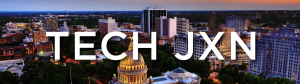 TECH JXN logo on a photo background of the city of Jackson at night